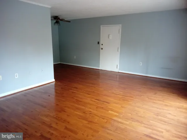 a view of an empty room with wooden floor