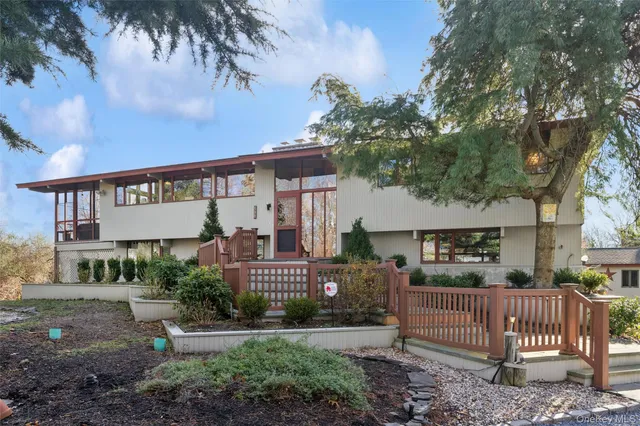 a view of a house with a yard and wooden fence