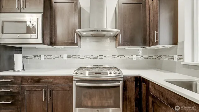 a view of a kitchen with sink stove and microwave