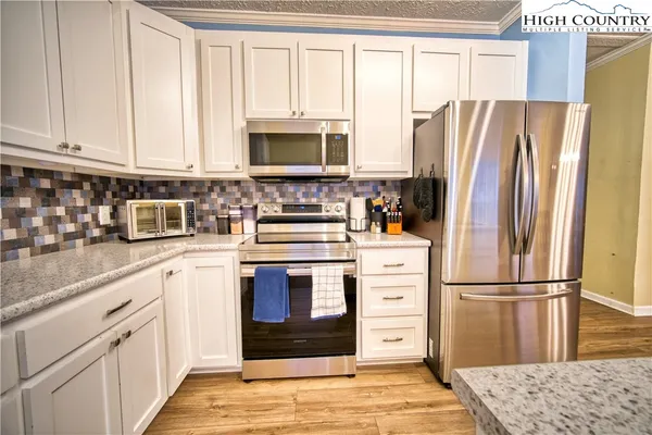 a kitchen with white cabinets and stainless steel appliances