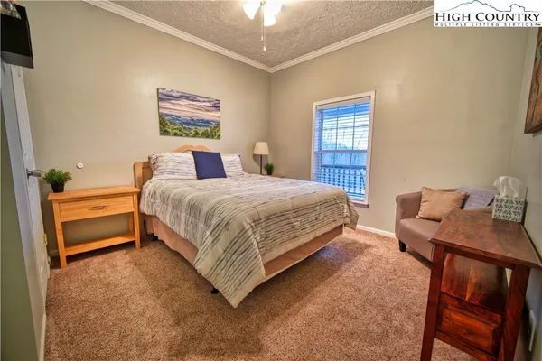 a bedroom with a bed table and chair