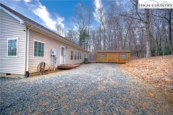 a view of a house with backyard and trees