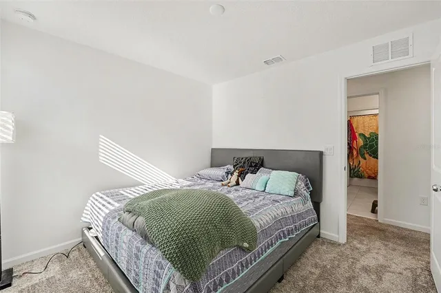 a bedroom with a bed and painting on the wall