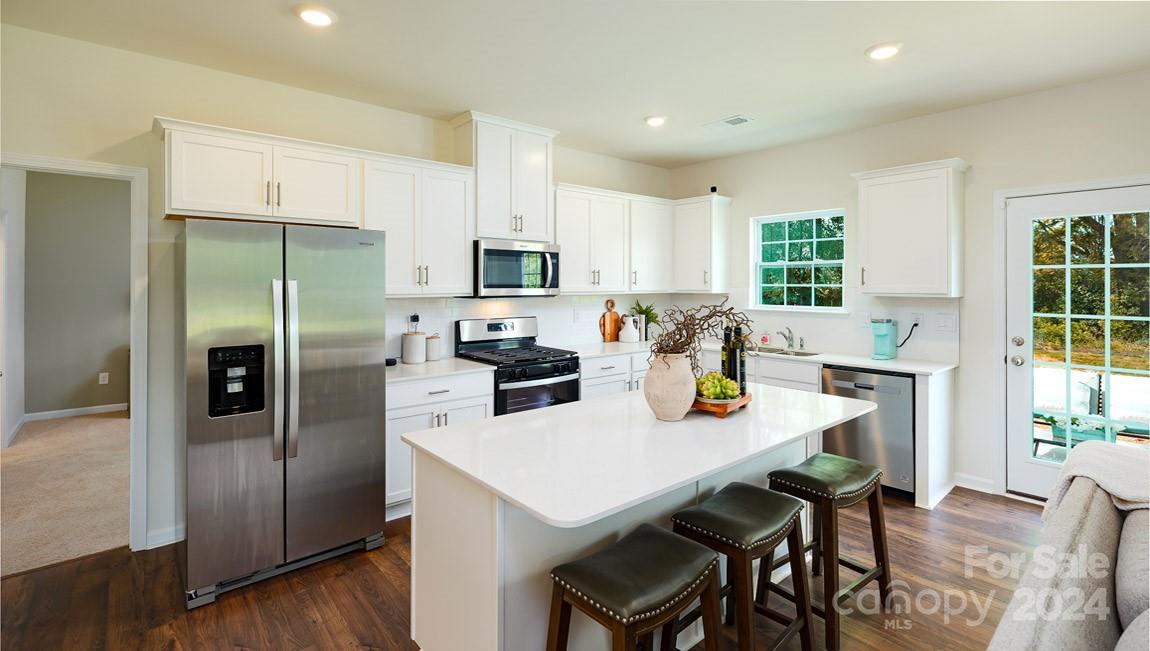 90 Shorthorn Road Fletcher, NC 28732 - Photo 3 of 25 a kitchen with stainless steel appliances a table chairs refrigerator and microwave