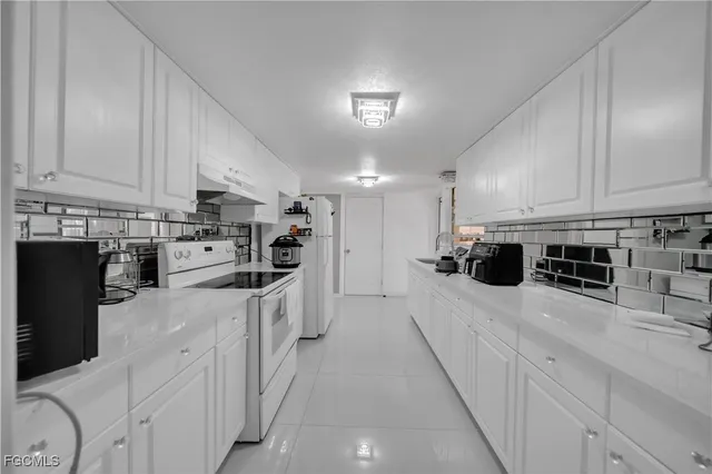 a kitchen with stainless steel appliances kitchen island granite countertop a stove sink and cabinets