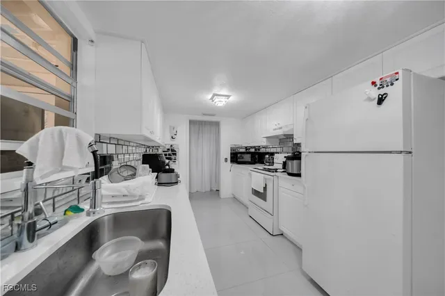 a kitchen with stainless steel appliances granite countertop a sink refrigerator and cabinets