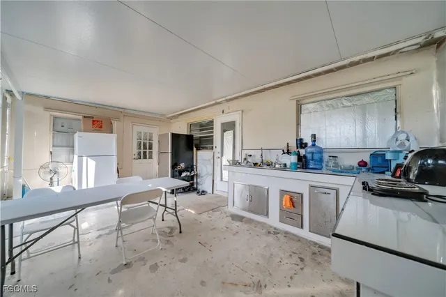 a large white kitchen with sink and cabinets