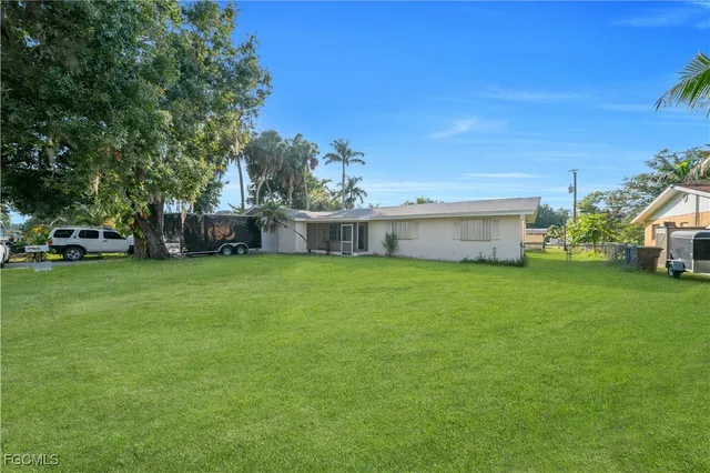a yellow house with trees in the background