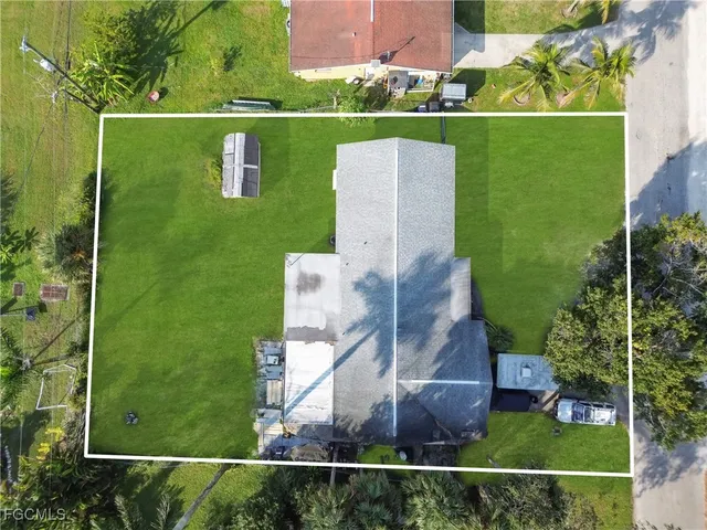 an aerial view of a house with a garden and lake view