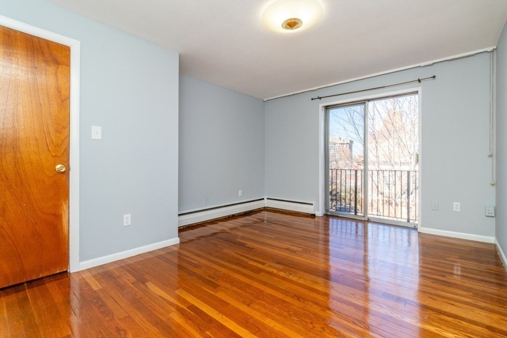 57 St Paul Street, Unit 19 Brookline, MA 02446 - Photo 12 of 23 a view of an empty room with wooden floor and a window
