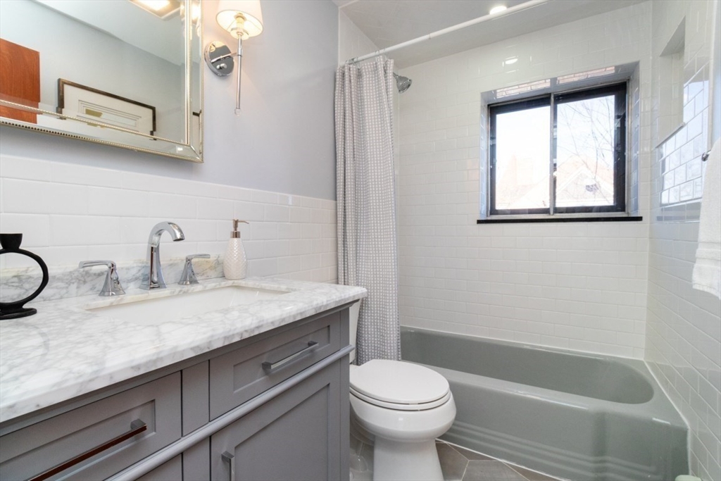 57 St Paul Street, Unit 19 Brookline, MA 02446 - Photo 13 of 23 a bathroom with a granite countertop sink mirror vanity and toilet