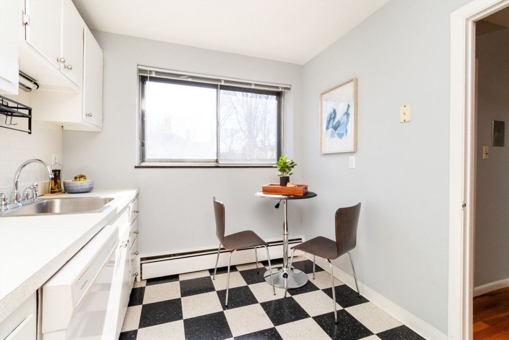 57 St Paul Street, Unit 19 Brookline, MA 02446 - Photo 9 of 23 a kitchen with a checkered floor and white cabinets