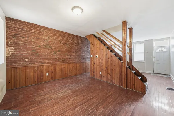 a view of a hallway with wooden floor and staircase