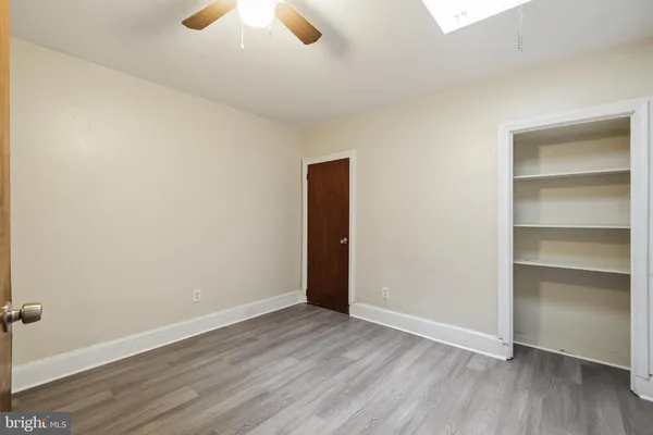 an empty room with wooden floor and closet