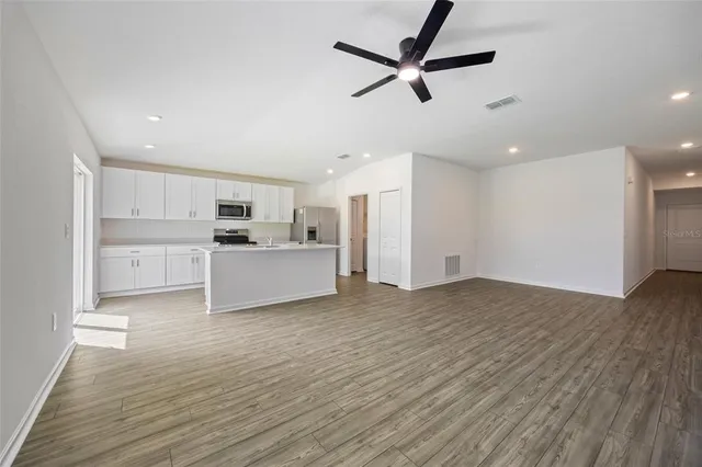 a view of a kitchen with a sink and dishwasher a refrigerator with wooden floor