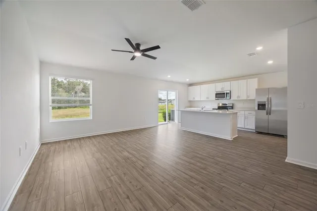 a view of a kitchen with a sink a refrigerator and window