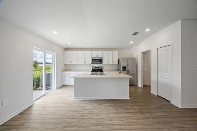 a view of kitchen with sink and refrigerator