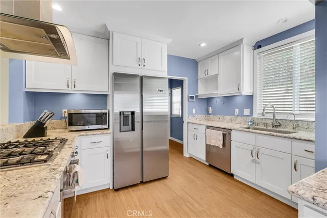 a kitchen with granite countertop white cabinets and sink