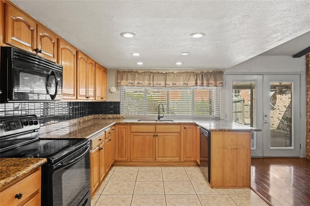 5619 Pine Row Street Houston, TX 77049 - Photo 6 of 8 a kitchen with stainless steel appliances granite countertop a sink stove and cabinets