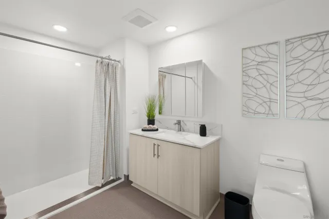 a bathroom with a granite countertop sink a toilet and a mirror