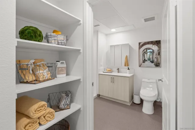 a bathroom with a toilet a sink and wooden floor