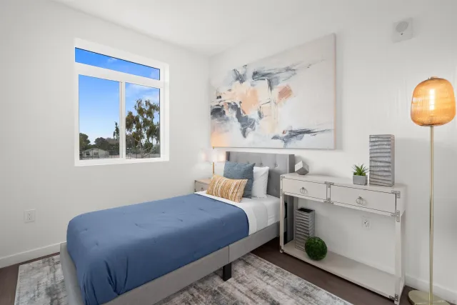 a bedroom with a bed and a painting on the wall