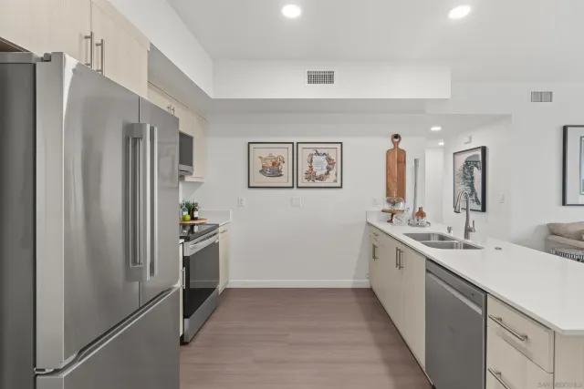 a kitchen with stainless steel appliances granite countertop a refrigerator and a sink