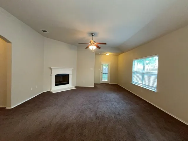 a view of a livingroom with a fireplace and a chandelier fan
