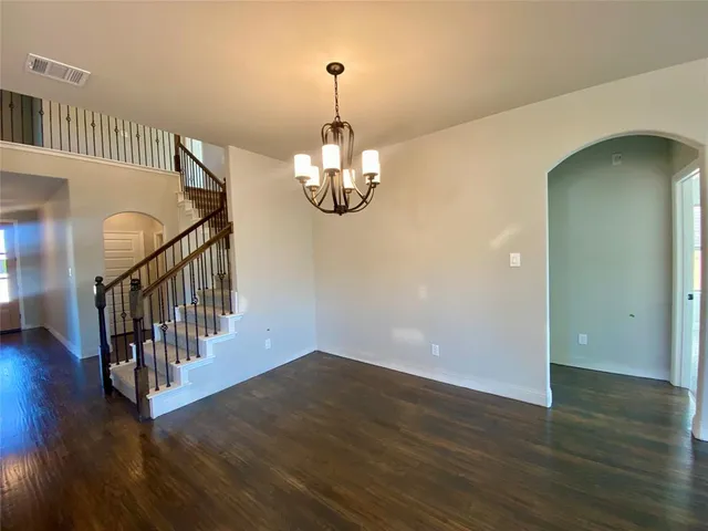 a view of staircase with wooden floor and a chandelier