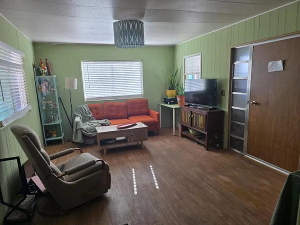 a living room with furniture and a wooden floor