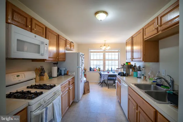 a kitchen with lots of counter top space a sink appliances and cabinets