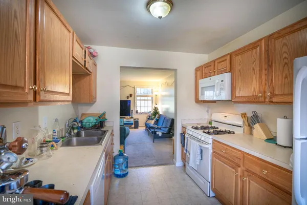 a kitchen with a refrigerator a stove a sink dishwasher and cabinets with wooden floor