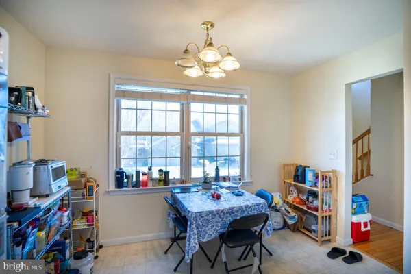 a dining room with lots of furniture and a chandelier