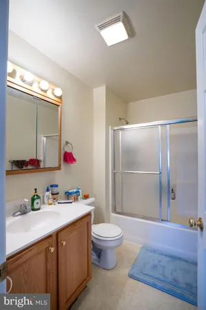 a spacious bathroom with a granite countertop sink a toilet and a shower