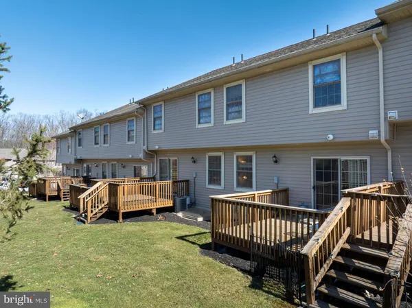 a view of a house with wooden deck and furniture