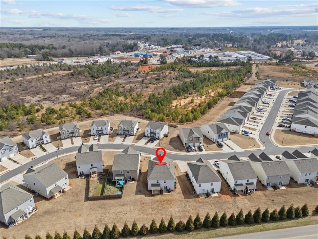 118 Adger Road Pendleton, SC 29670 - Photo 28 of 31 This aerial view showcases a residential community nestled amidst a natural landscape with distant commercial areas.
