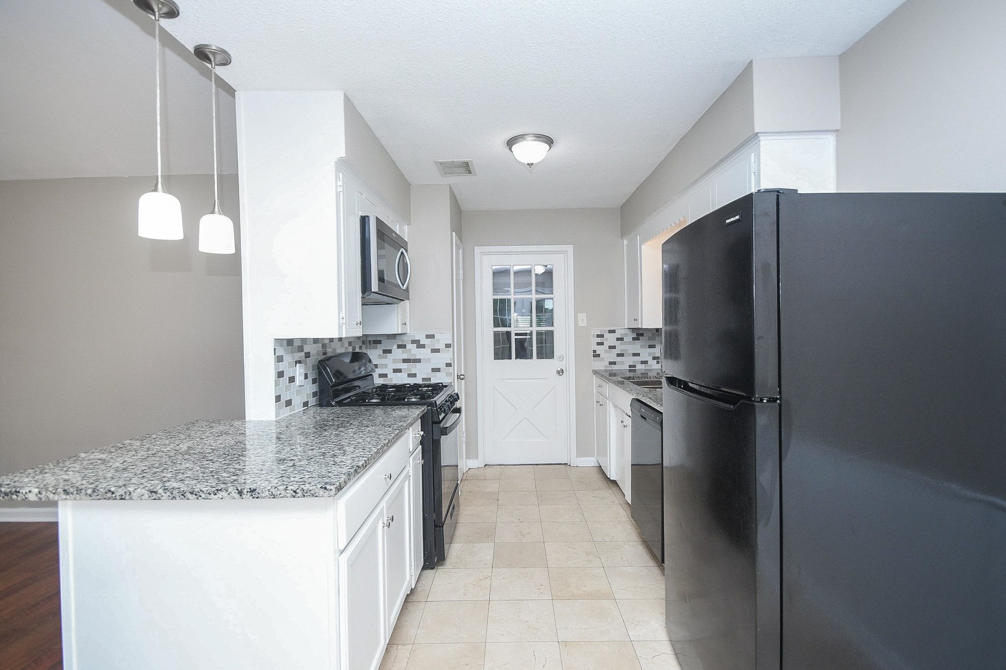 710 Barnesville Street Channelview, TX 77530 - Photo 7 of 20 Kitchen with pendant lighting and bright white cabinets.