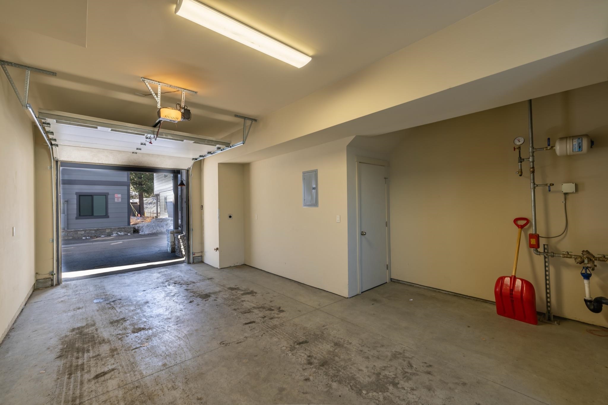 Garage featuring electric panel and a garage door opener