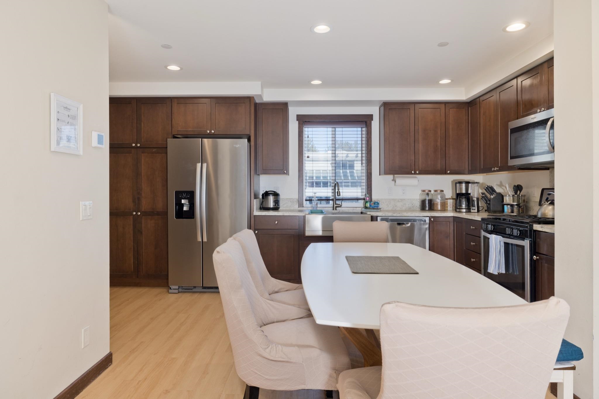 28 Oak Tree Way, Unit 8 Mammoth Lakes, CA 93546 - Photo 8 of 32 Kitchen with stainless steel appliances, dark wood finish cabinetry, recessed lighting, light wood-type flooring, and a kitchen bar