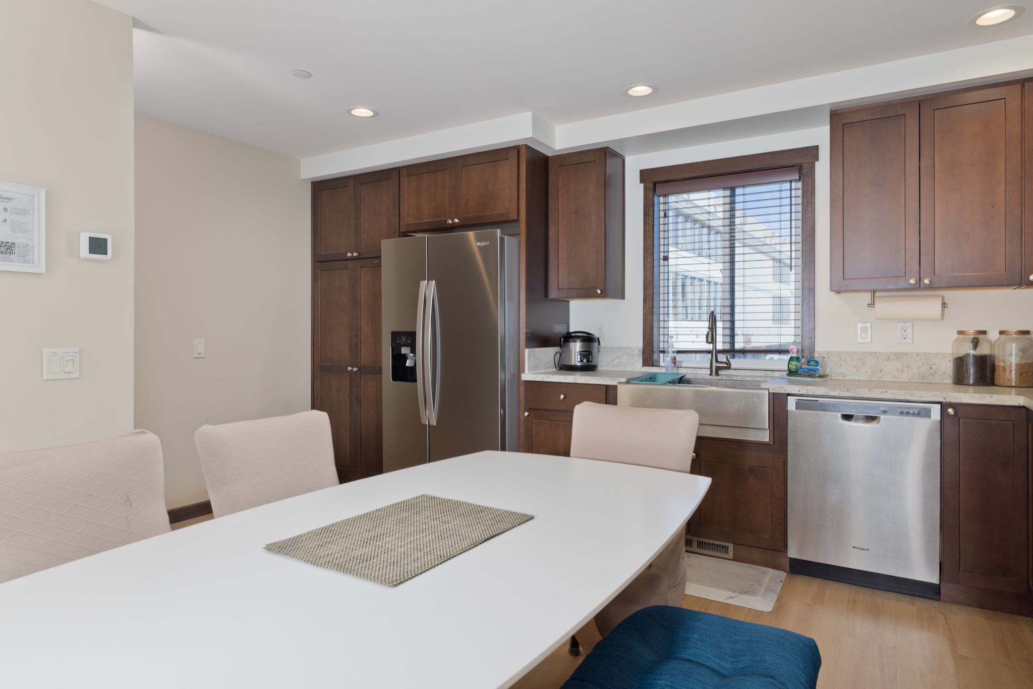 28 Oak Tree Way, Unit 8 Mammoth Lakes, CA 93546 - Photo 9 of 32 Kitchen featuring stainless steel appliances, a breakfast bar, recessed lighting, dark wood finish cabinetry, and light wood-style flooring