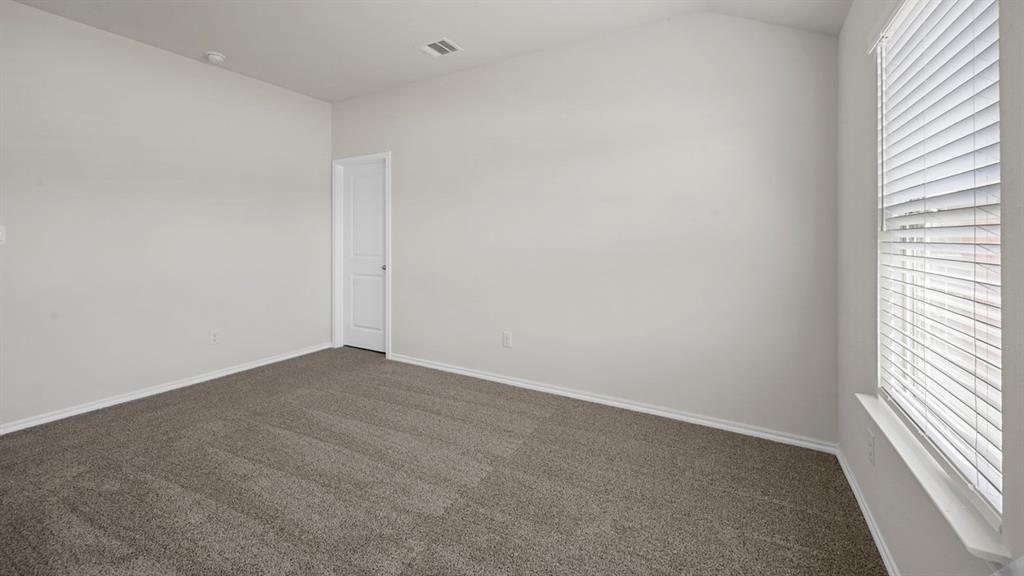 1913 Freeman Street Tyler, TX 75704 - Photo 11 of 21 Unfurnished room featuring dark colored carpet, plenty of natural light, and lofted ceiling