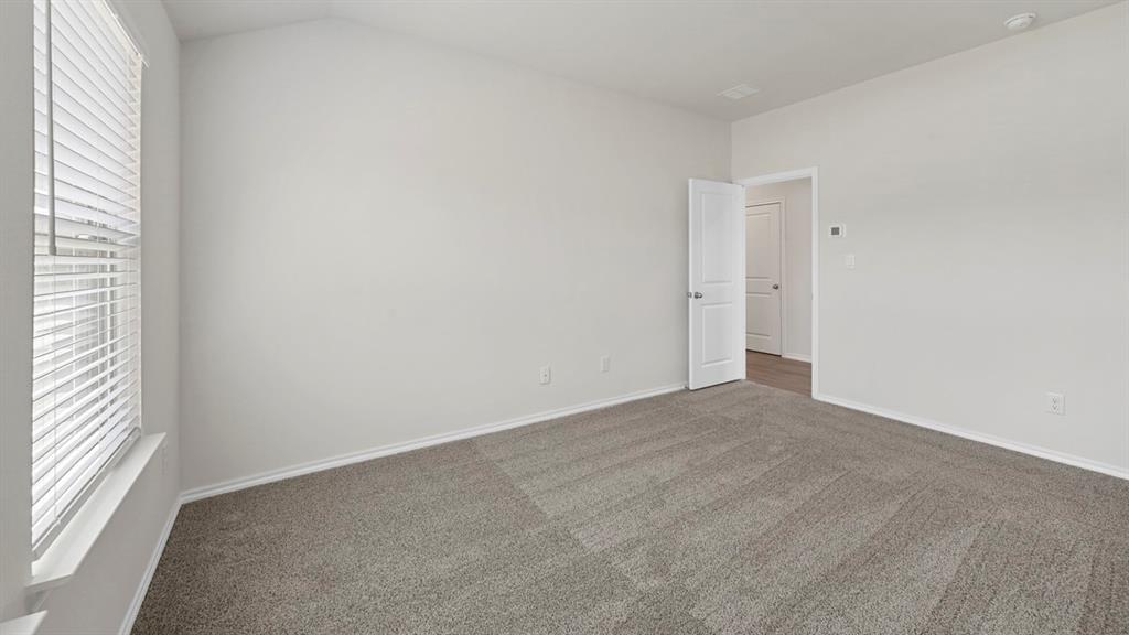 1913 Freeman Street Tyler, TX 75704 - Photo 18 of 21 Empty room with dark colored carpet and vaulted ceiling