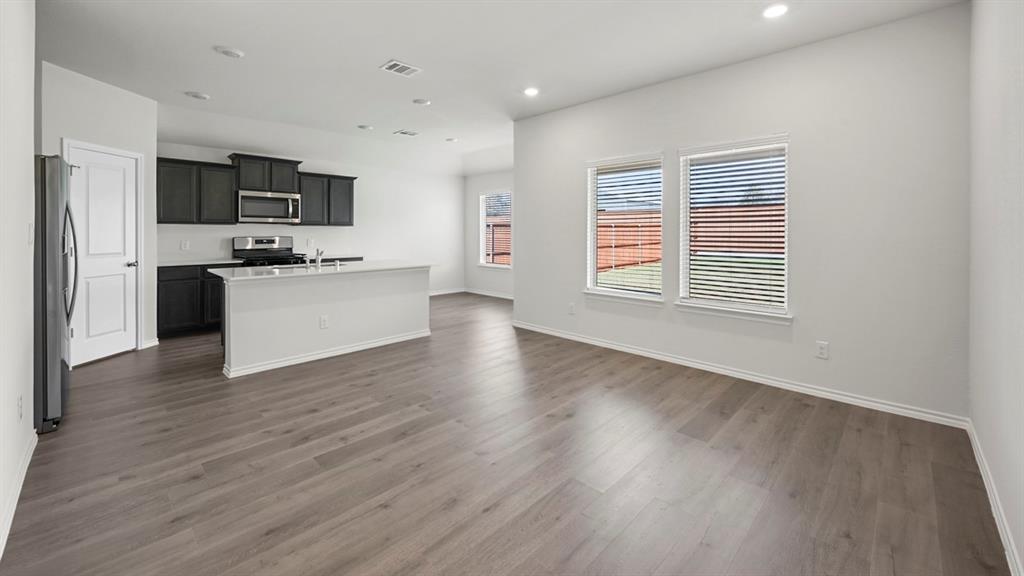 1913 Freeman Street Tyler, TX 75704 - Photo 20 of 21 Kitchen featuring a kitchen island with sink, open floor plan, stainless steel appliances, recessed lighting, and dark wood-type flooring