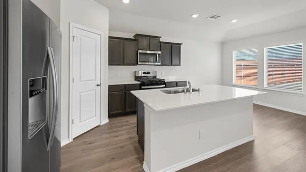 a kitchen with stainless steel appliances a microwave sink and refrigerator