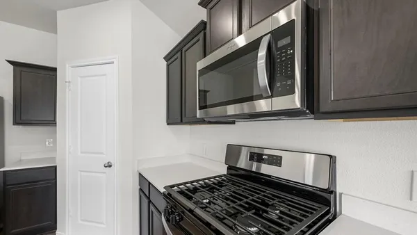 a kitchen with stainless steel appliances a sink a stove a refrigerator a center island and a window