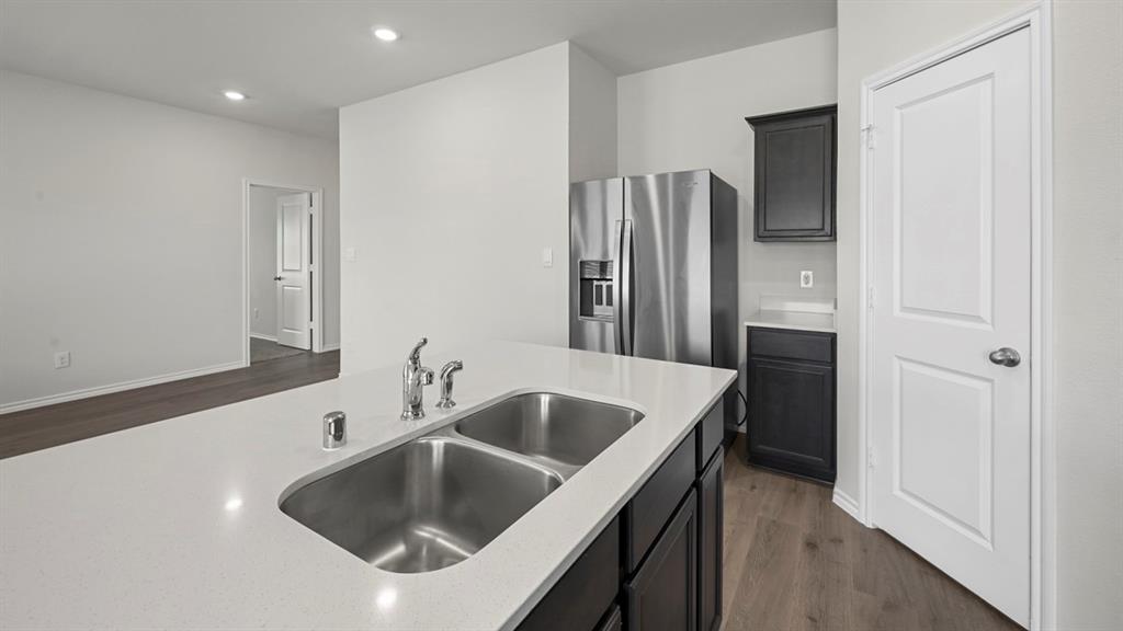 1913 Freeman Street Tyler, TX 75704 - Photo 6 of 21 Kitchen featuring dark cabinetry, dark wood-style flooring, stainless steel fridge with ice dispenser, recessed lighting, and light stone countertops