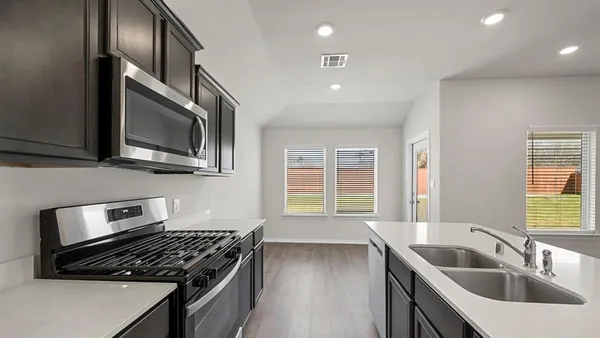 a kitchen with stainless steel appliances granite countertop a refrigerator and a sink
