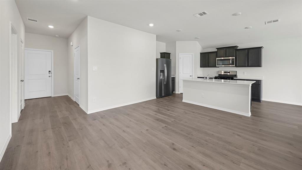 1913 Freeman Street Tyler, TX 75704 - Photo 21 of 21 Kitchen with stainless steel appliances, open floor plan, an island with sink, recessed lighting, and dark wood finished floors