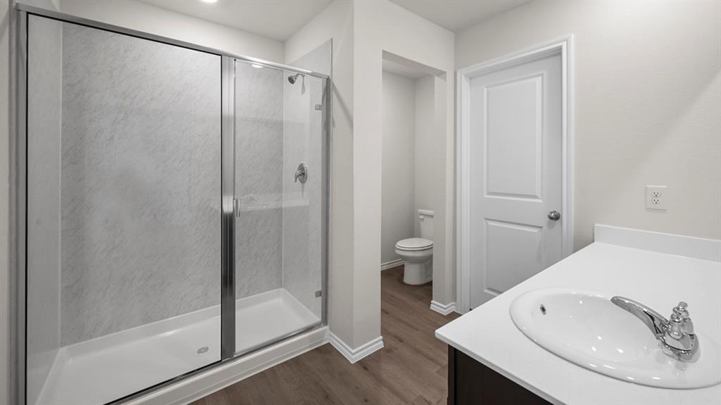 1913 Freeman Street Tyler, TX 75704 - Photo 8 of 21 Full bathroom with vanity, a stall shower, and dark wood-style floors