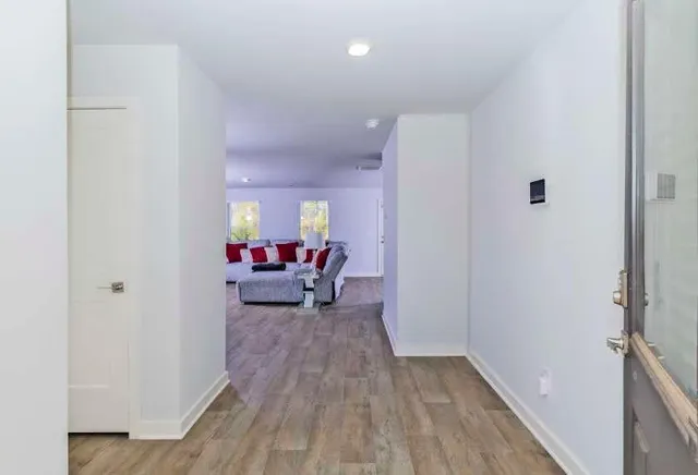 a view of a bedroom with a bed and wooden floor